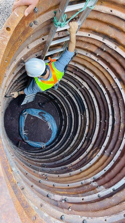 Engenheiro descendo em poço de inspeção